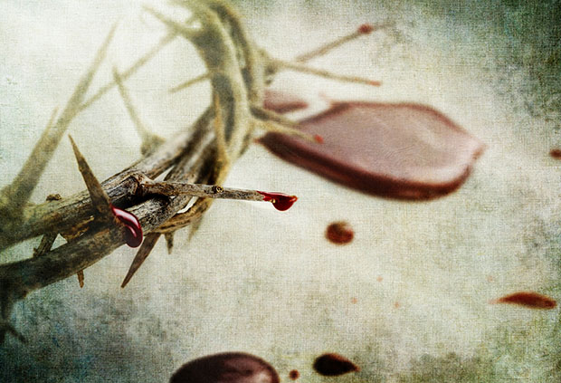 Crown of thorns with drops of blood over grunged background.